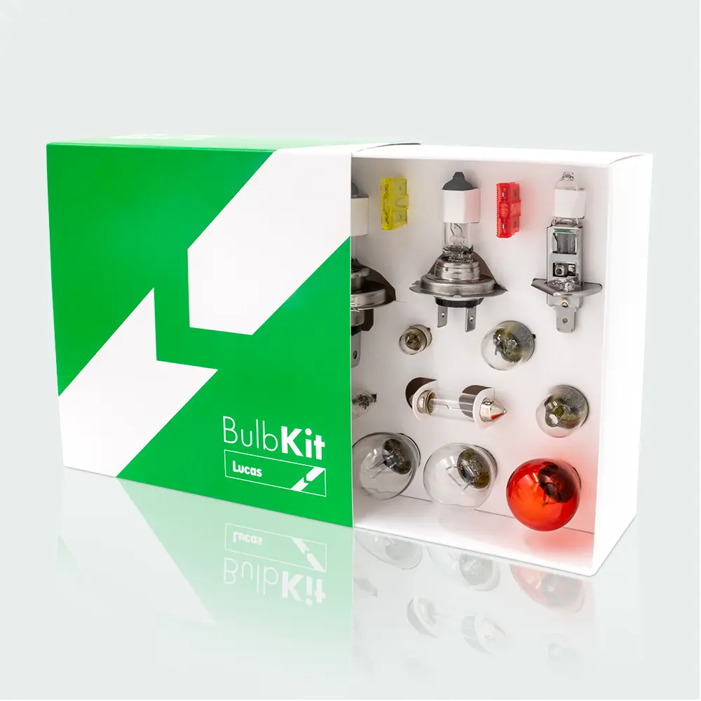 A boxed automotive bulb kit containing various vehicle bulbs and fuses, displayed inside white packaging set on top of a green box labeled “BulbKit Lucas.”