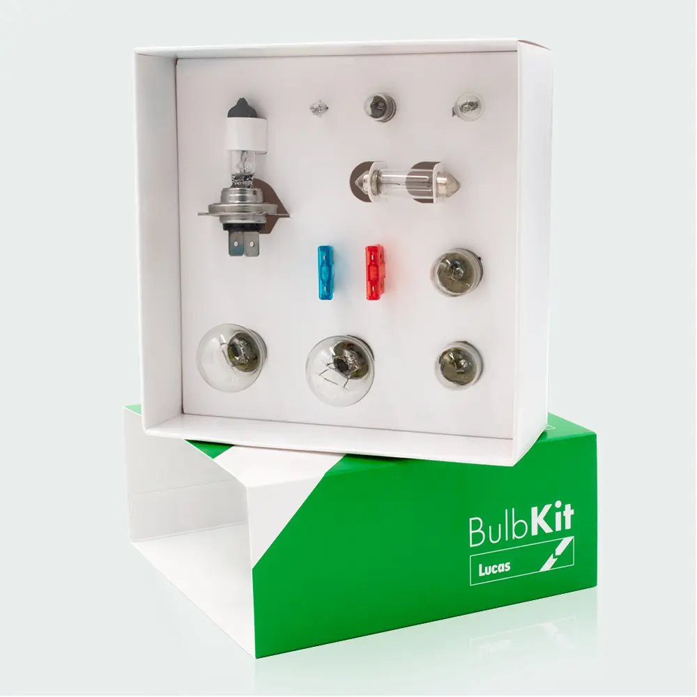 A boxed automotive bulb kit containing various vehicle bulbs and fuses, displayed inside white packaging set on top of a green box labeled “BulbKit Lucas.”